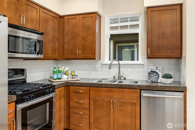 a kitchen with stainless steel appliances granite countertop a sink stove and microwave