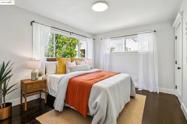 a bedroom with a bed and a lamp on dresser