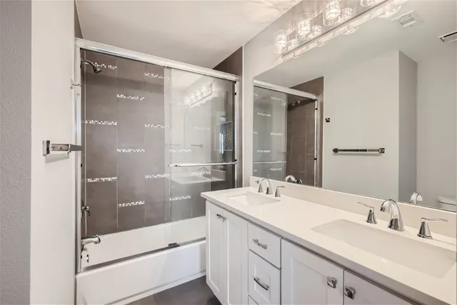 a bathroom with a double vanity sink mirror double and shower