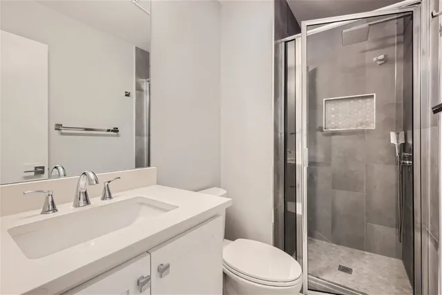 a bathroom with a sink a toilet and shower