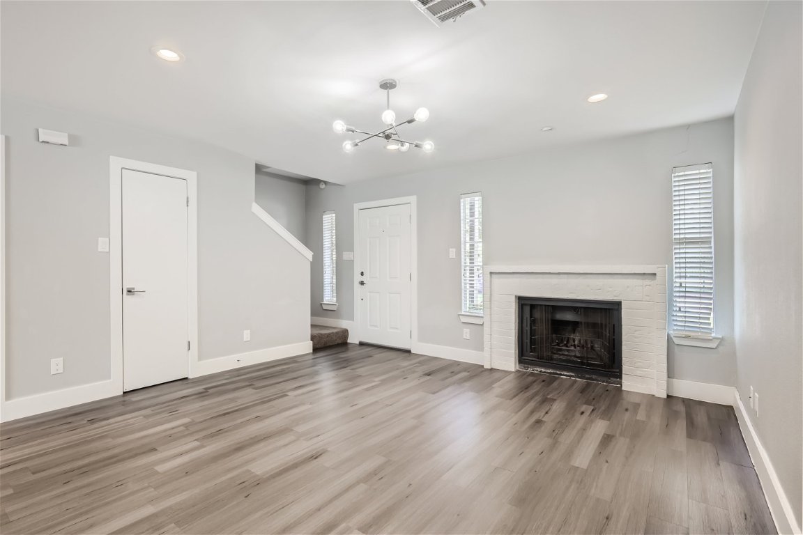 1830 River Crossing Circle, Unit D Austin, TX 78741 - Photo 3 of 27 an empty room with wooden floor fireplace and window