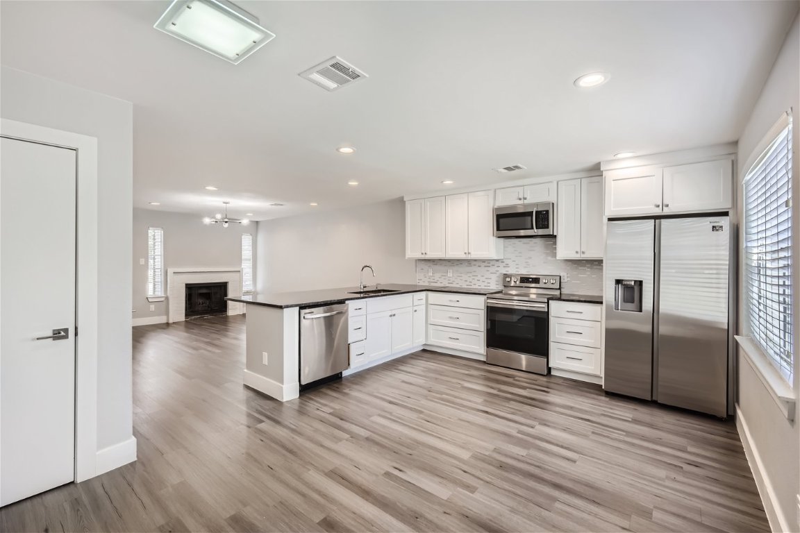 1830 River Crossing Circle, Unit D Austin, TX 78741 - Photo 6 of 27 a kitchen with a refrigerator and a stove top oven