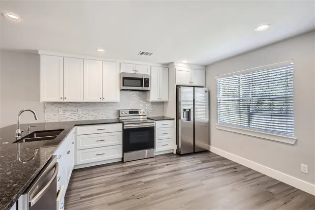 a kitchen with kitchen island granite countertop a stove a sink and a refrigerator