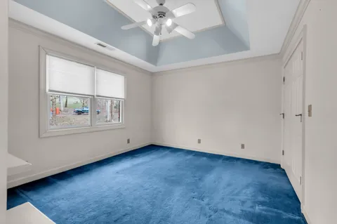 an empty room with windows and ceiling fan