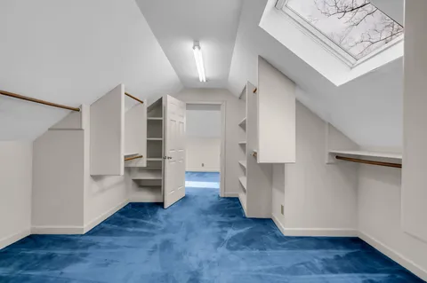 a view of a kitchen with wooden floors and white cabinets