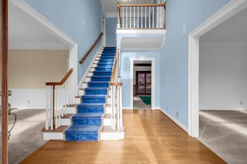 a view of entryway and hall with wooden floor