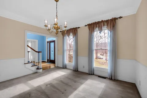 a view of a livingroom with a chandelier closet and windows