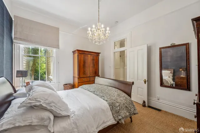 a bedroom with a large bed and a chandelier