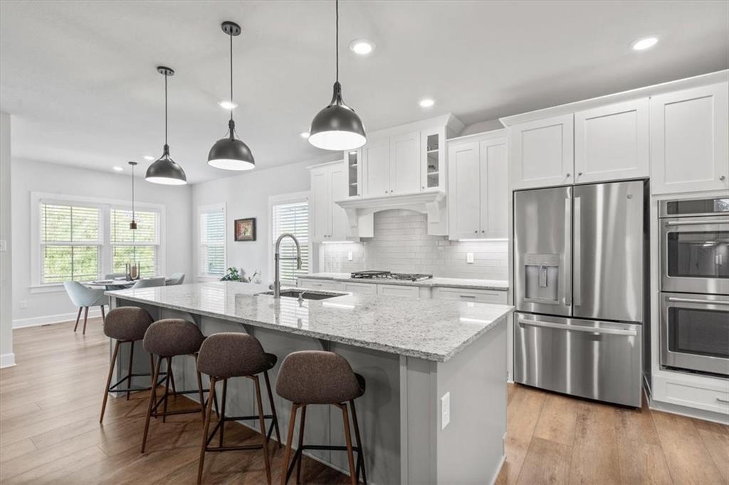 345 Crest Lane Mars, PA 16046 - Photo 8 of 42 a kitchen with stainless steel appliances granite countertop a sink a stove a refrigerator and island with wooden floor
