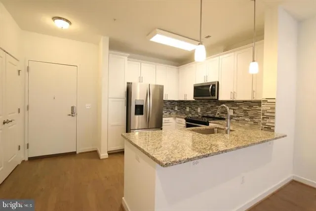 a kitchen with a refrigerator a microwave and sink