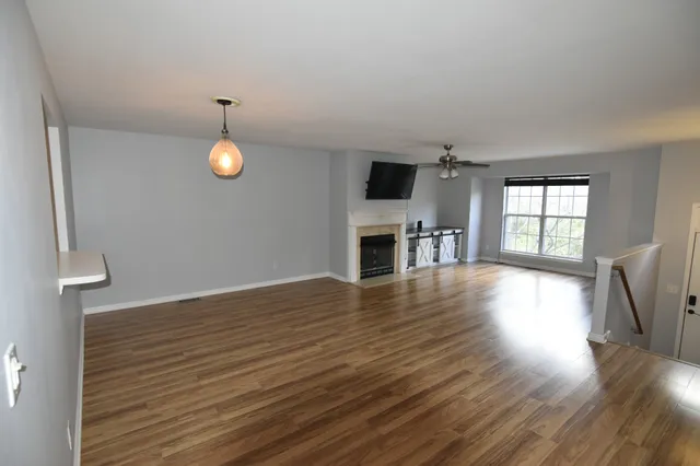 a view of empty room with wooden floor and window