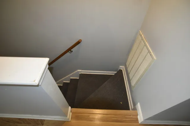 a view of a hallway with wooden floor and entryway
