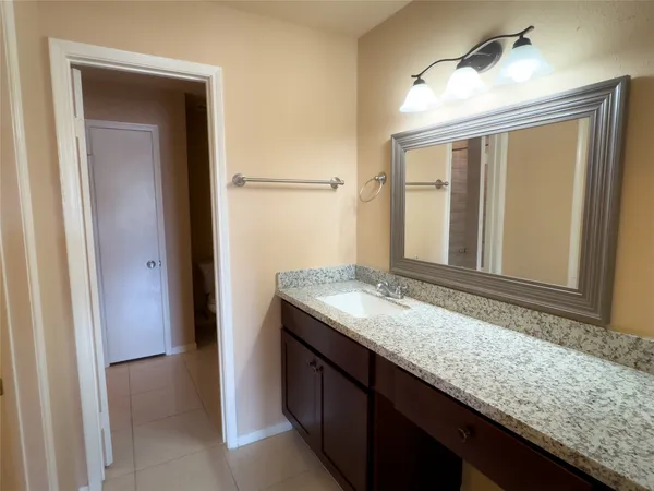 a bathroom with a granite countertop sink and a mirror