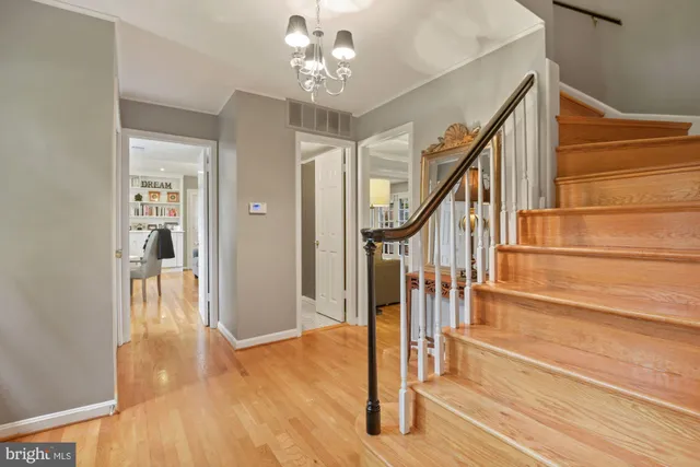 a view of a hallway with wooden floor and staircase