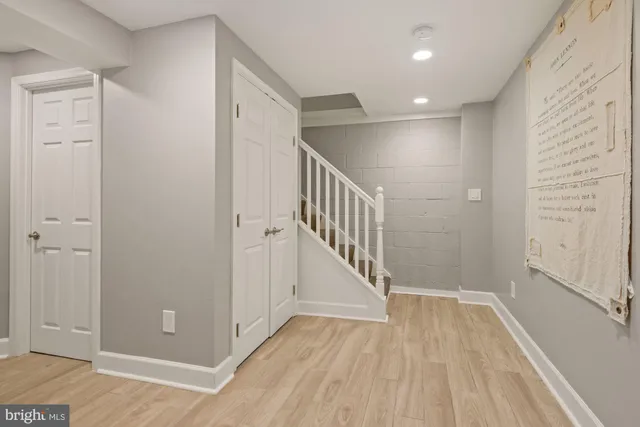 a view of a hallway with wooden floor and staircase