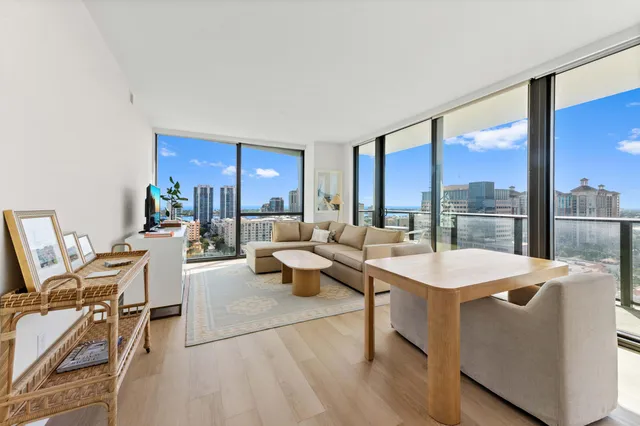 a living room with furniture a large window and a table