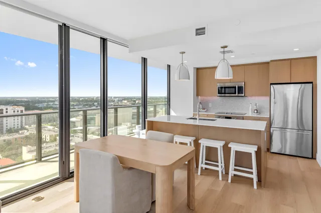 a kitchen with a table chairs refrigerator and cabinets
