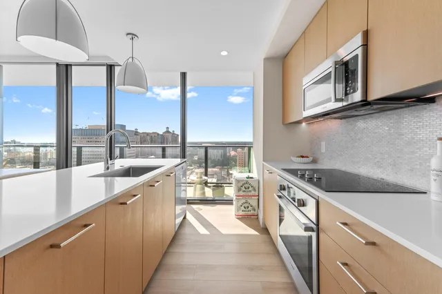 a kitchen with stainless steel appliances granite countertop a sink and a wooden floors