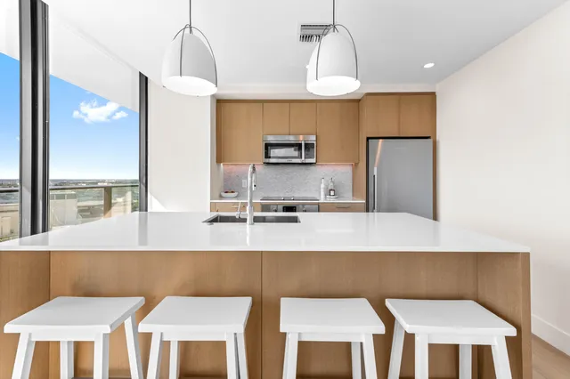 a kitchen with stainless steel appliances granite countertop a kitchen island a stove a table and chairs