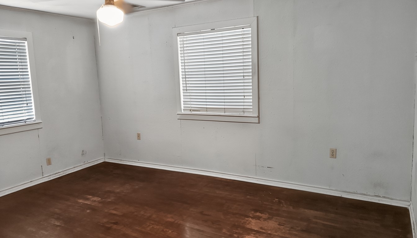 11913 McAngus Road Del Valle, TX 78617 - Photo 32 of 45 an empty room with wooden floor and windows