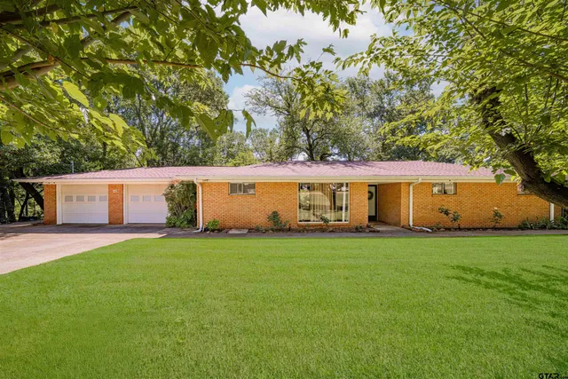 a front view of house with yard and trees