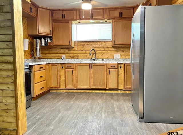 a view of a kitchen with wooden floor and electronic appliances