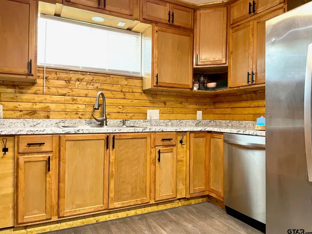 a kitchen with stainless steel appliances granite countertop a refrigerator and a sink