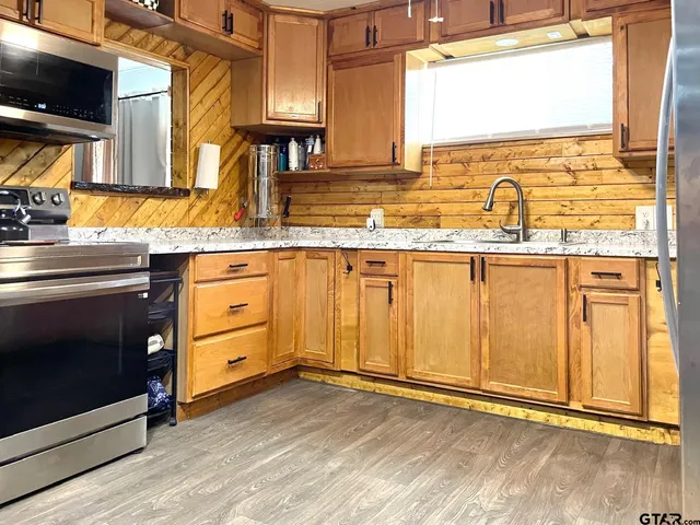 a kitchen with granite countertop a sink and a stove