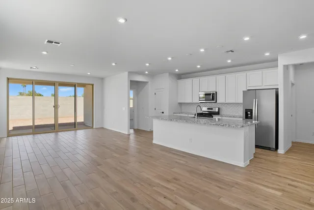 a large kitchen with stainless steel appliances granite countertop a large counter top a stove and a refrigerator