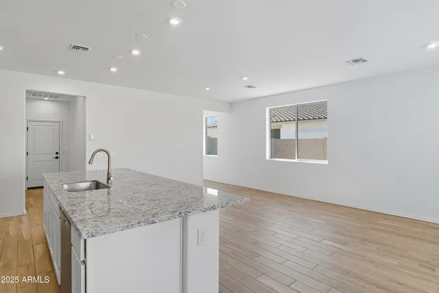 a kitchen with granite countertop sink and natural light