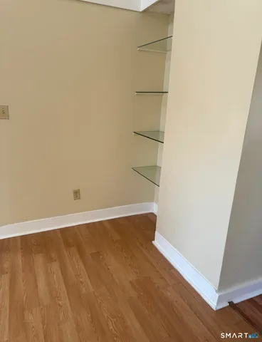 an empty room with wooden floor and cabinet