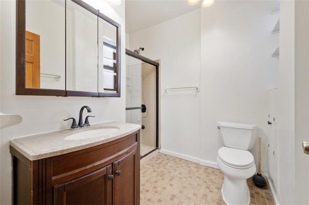 7119 Shore Road, Unit 2G Brooklyn, NY 11209 - Photo 15 of 22 a bathroom with a sink a toilet and a mirror