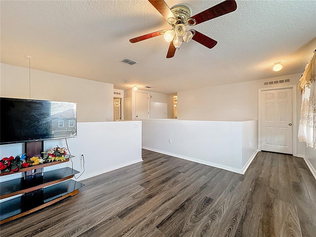 2620 Hunley Loop Kissimmee, FL 34743 - Photo 17 of 52 a view of an empty room with a window and wooden floor