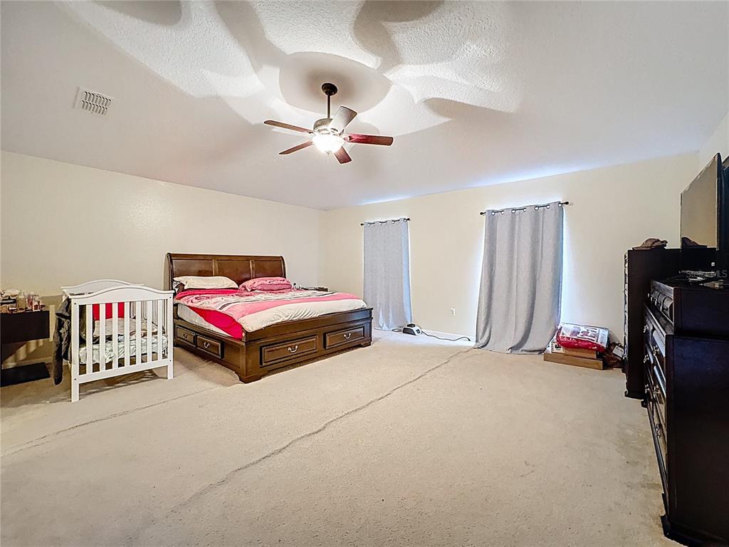 2620 Hunley Loop Kissimmee, FL 34743 - Photo 23 of 52 a bed room with a bed and a ceiling fan