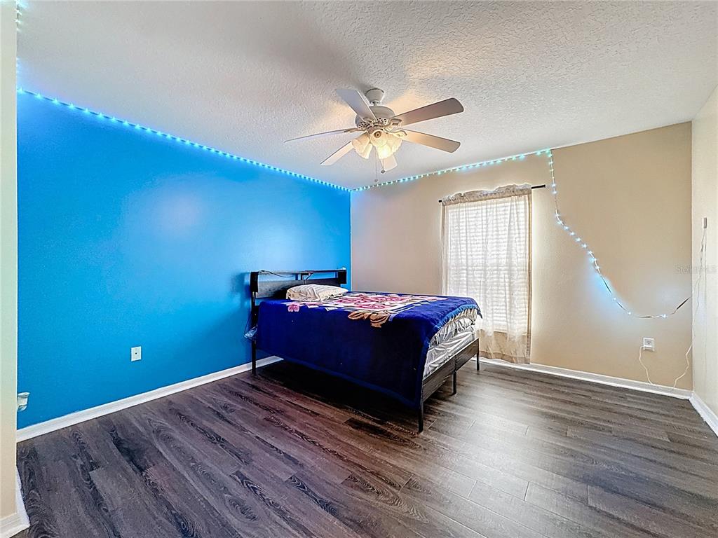 2620 Hunley Loop Kissimmee, FL 34743 - Photo 24 of 52 a bedroom with a bed and a ceiling fan