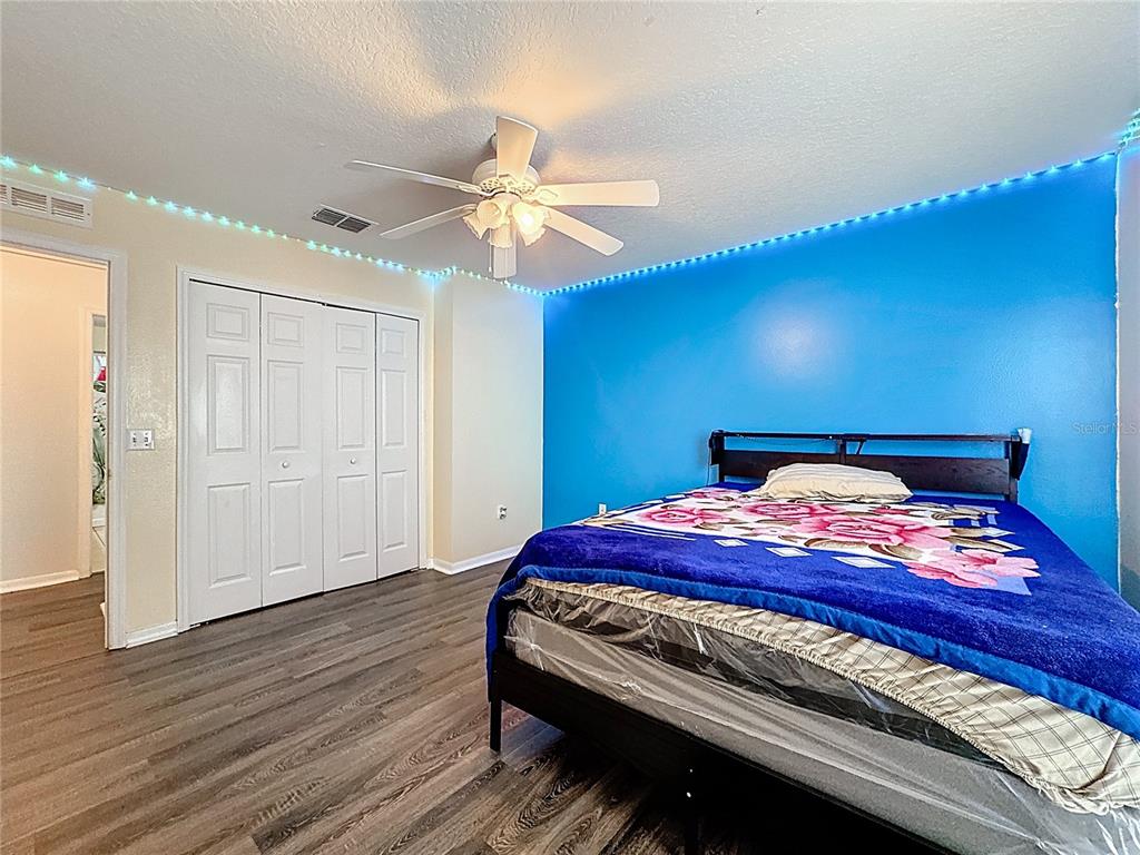 2620 Hunley Loop Kissimmee, FL 34743 - Photo 25 of 52 a bedroom with a bed and wooden floor