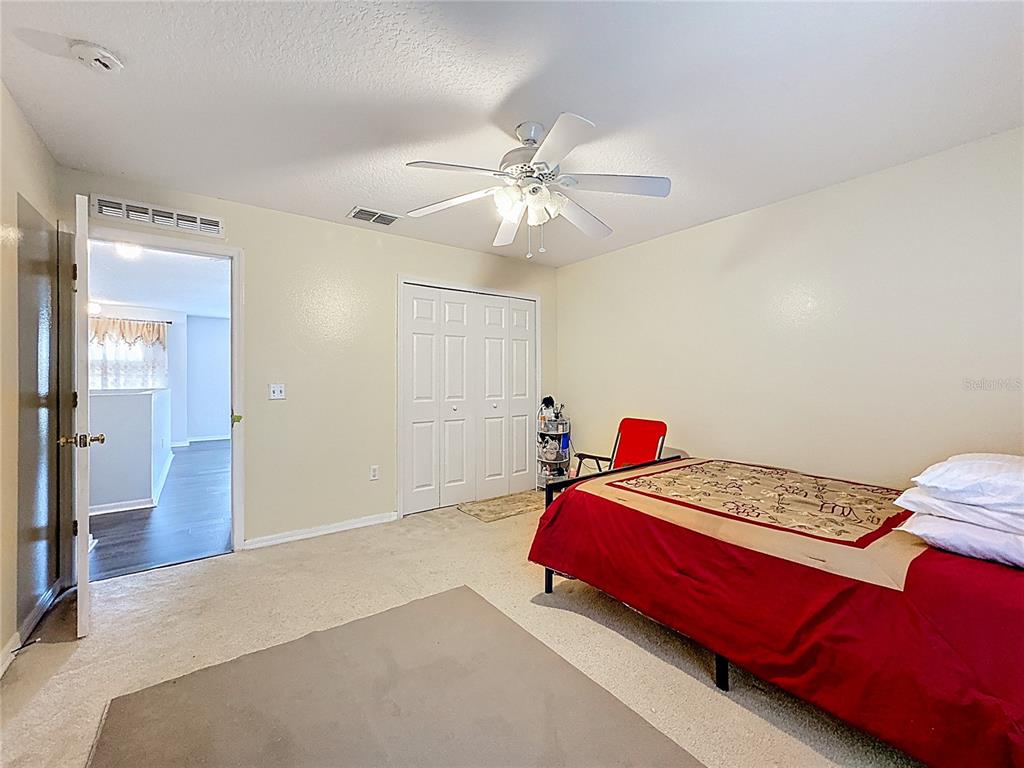 2620 Hunley Loop Kissimmee, FL 34743 - Photo 28 of 52 a bedroom with a bed and a chandelier
