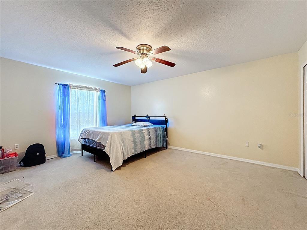2620 Hunley Loop Kissimmee, FL 34743 - Photo 30 of 52 a bedroom with a bed and a chandelier