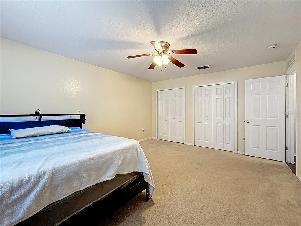 2620 Hunley Loop Kissimmee, FL 34743 - Photo 32 of 52 a bedroom with a bed and a ceiling fan