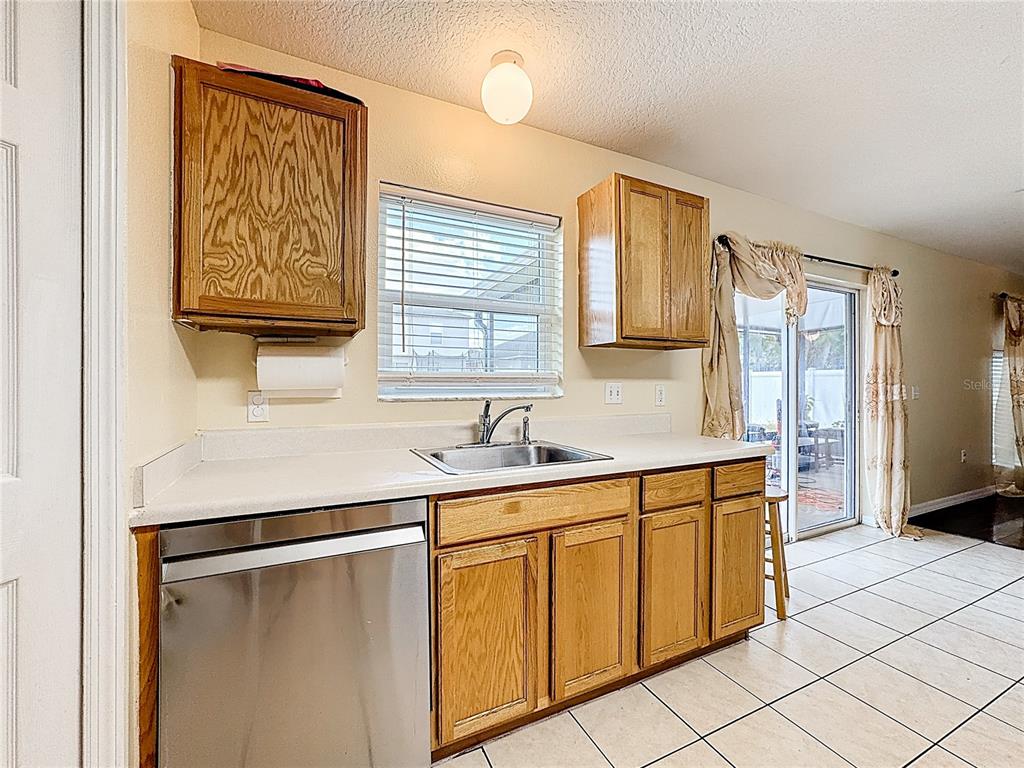 2620 Hunley Loop Kissimmee, FL 34743 - Photo 33 of 52 a kitchen with stainless steel appliances a sink stove and refrigerator