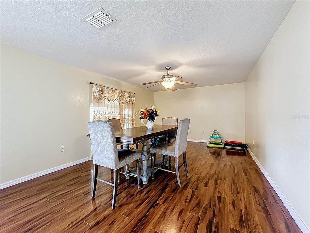 2620 Hunley Loop Kissimmee, FL 34743 - Photo 37 of 52 a view of a dining room with furniture and wooden floor