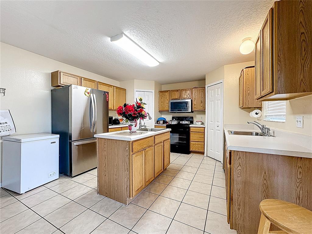 2620 Hunley Loop Kissimmee, FL 34743 - Photo 5 of 52 a kitchen with a sink refrigerator and microwave