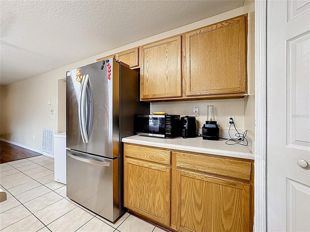 2620 Hunley Loop Kissimmee, FL 34743 - Photo 6 of 52 a kitchen with stainless steel appliances granite countertop a refrigerator a stove and a sink with cabinets