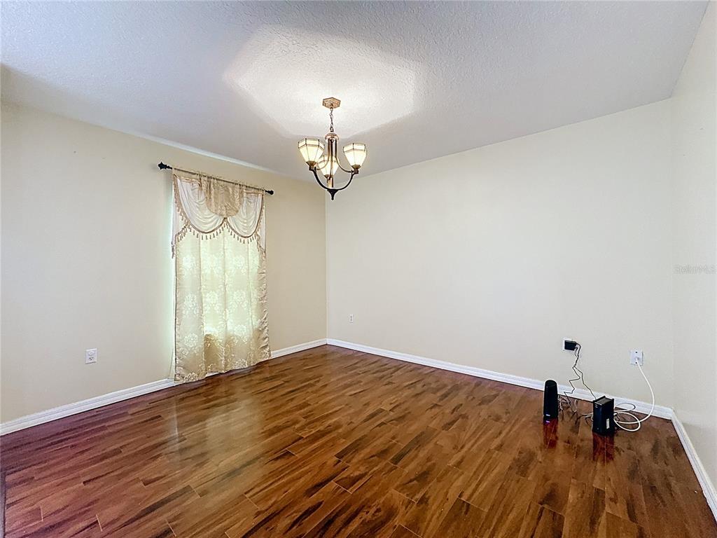 2620 Hunley Loop Kissimmee, FL 34743 - Photo 10 of 52 wooden floor in an empty room with a window