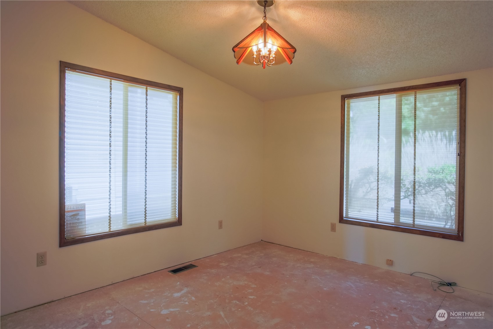 8168 Cultus Bay Road Clinton, WA 98236 - Photo 17 of 38 an empty room with windows and chandelier fan