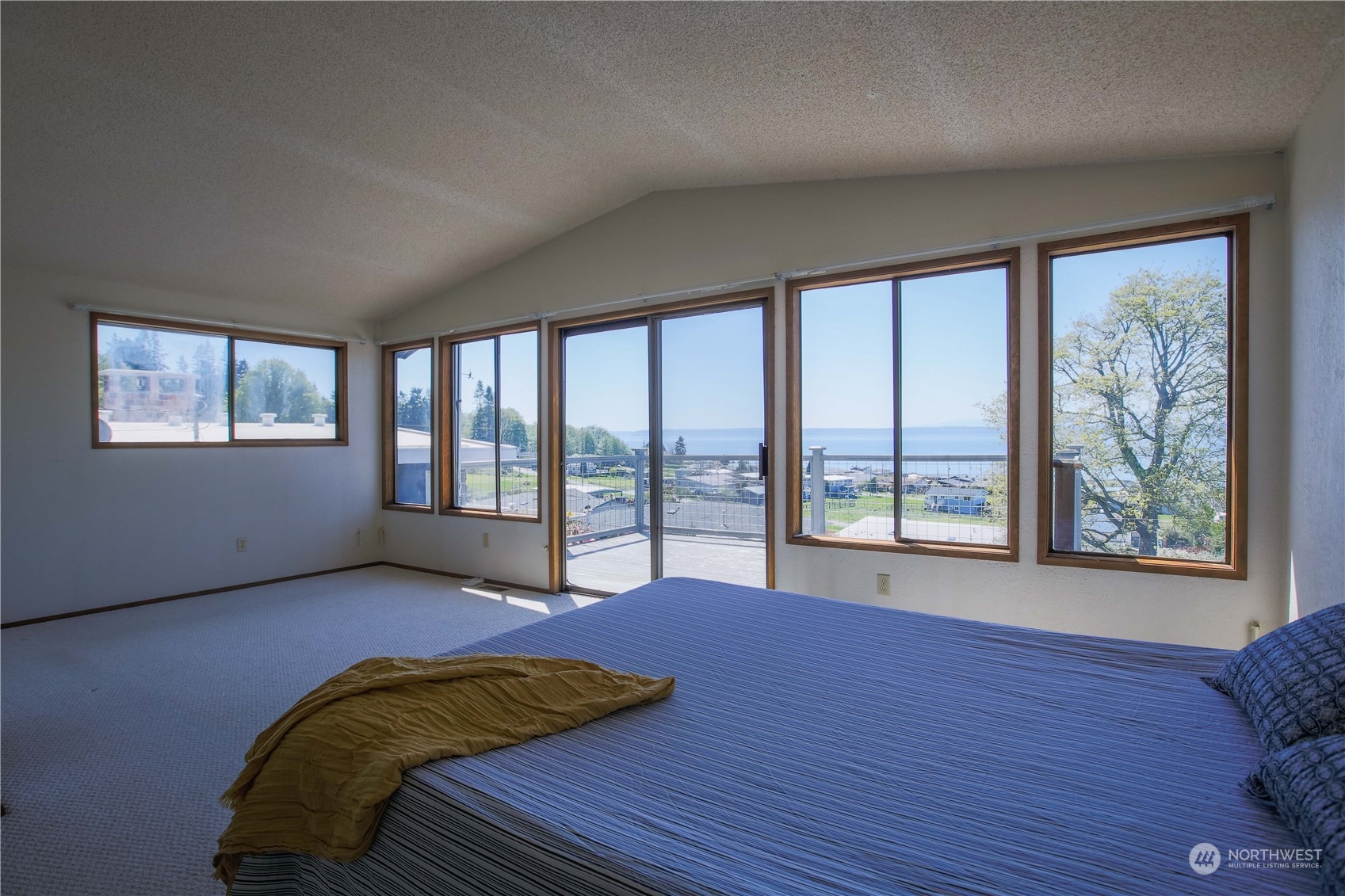 8168 Cultus Bay Road Clinton, WA 98236 - Photo 21 of 38 a view of a bedroom with furniture and large windows