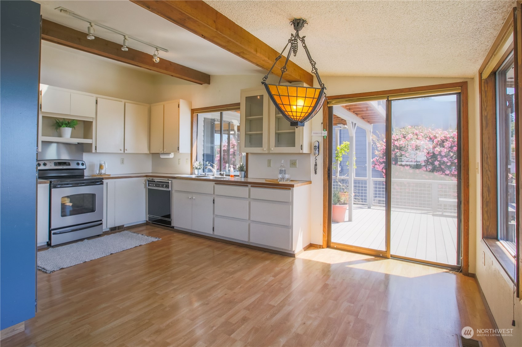 8168 Cultus Bay Road Clinton, WA 98236 - Photo 8 of 38 a kitchen with stainless steel appliances granite countertop a sink a stove and a wooden floors