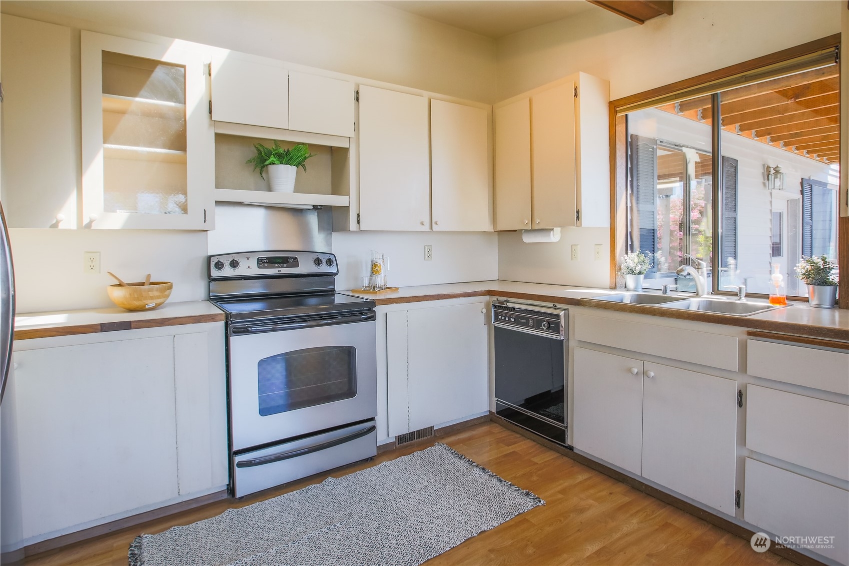 8168 Cultus Bay Road Clinton, WA 98236 - Photo 9 of 38 a kitchen with a stove a sink and a window