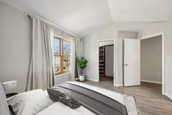 a bedroom with a bed and a large window