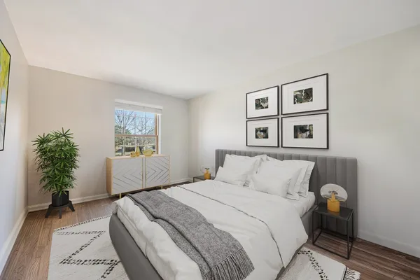 a bedroom with a large bed and a potted plant